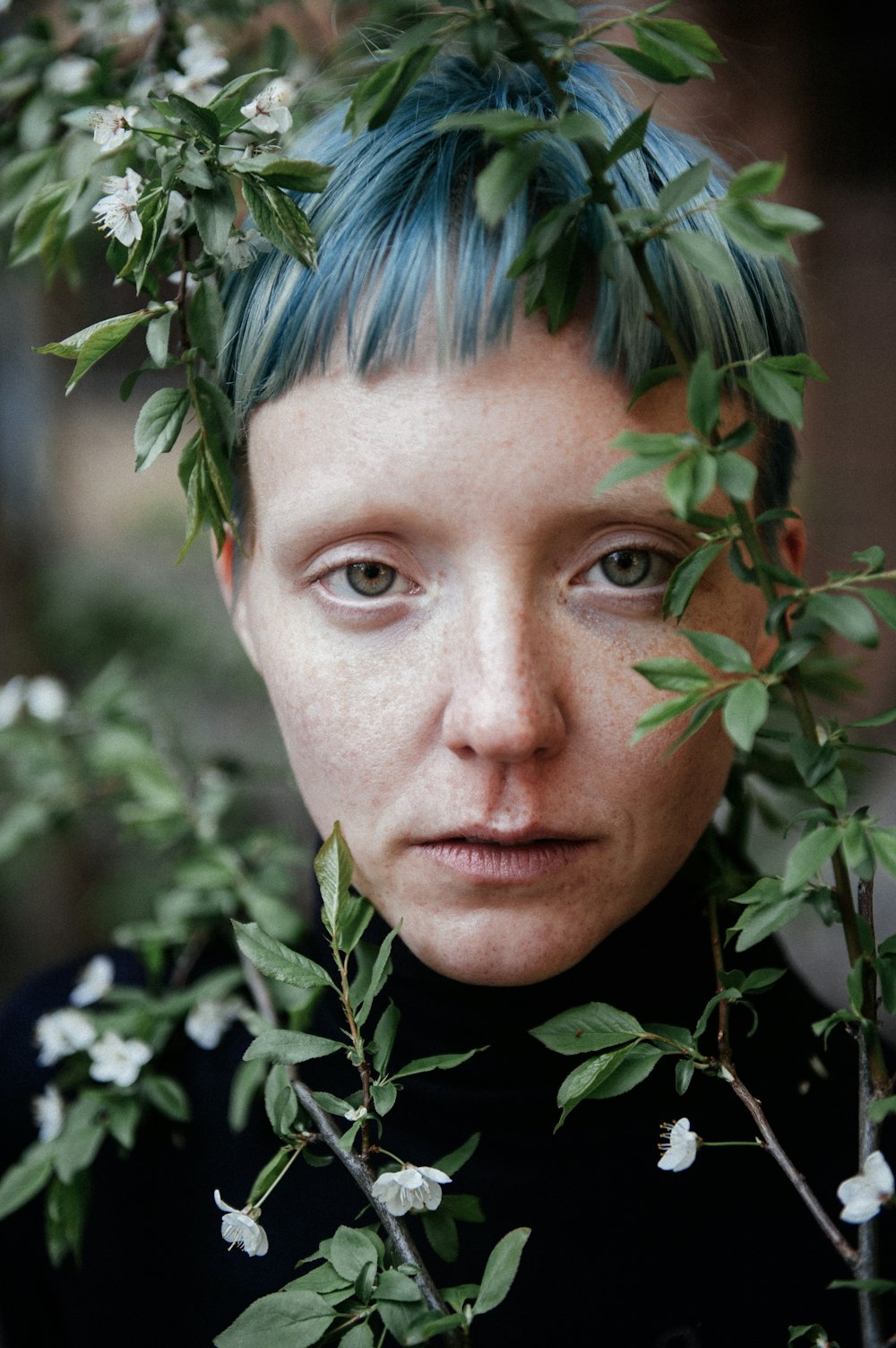 a woman with green hair and blue eyes