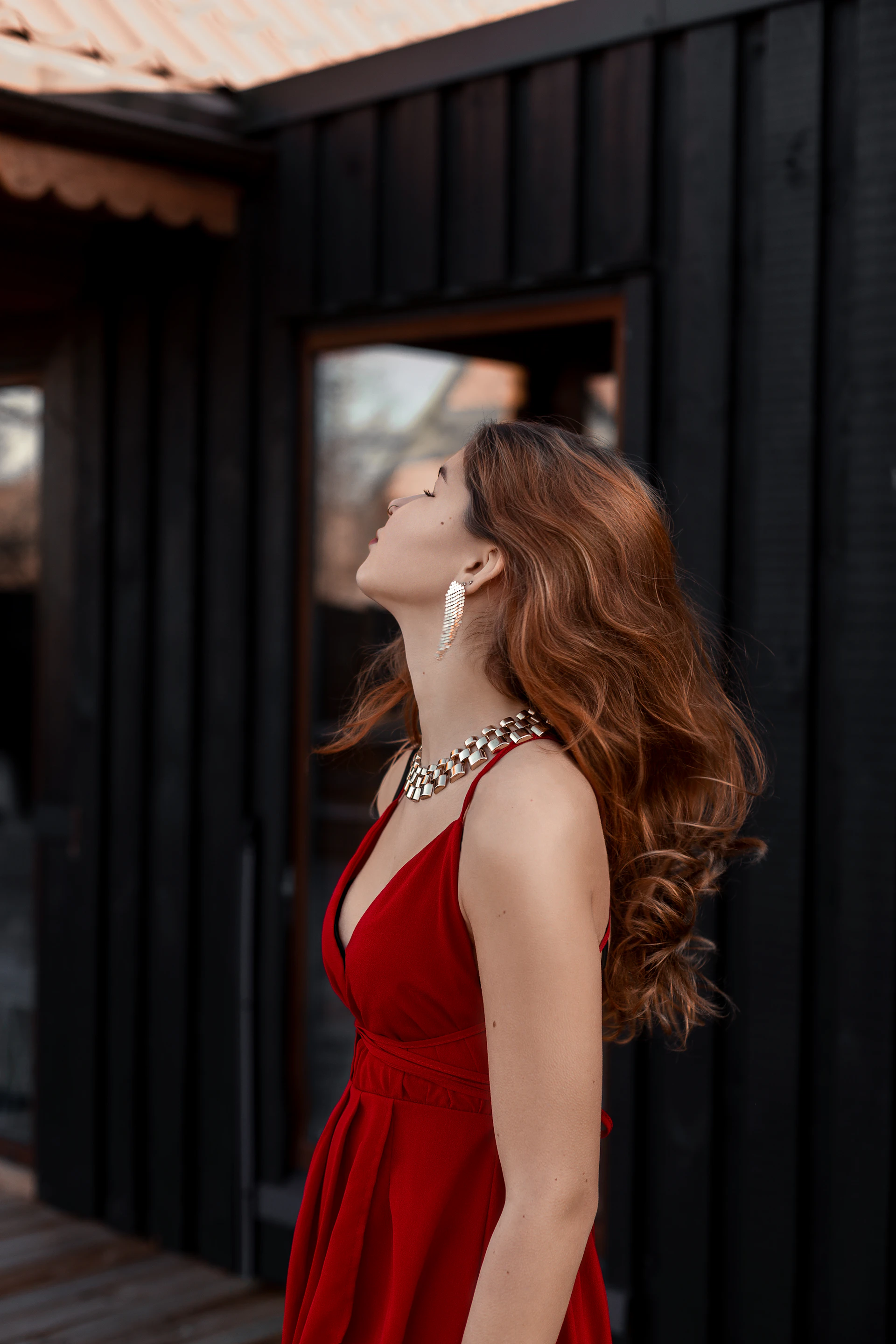 Elegant woman in red dress with flowing hair and jewelry