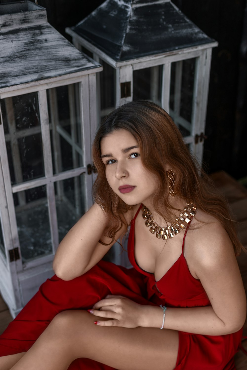 a woman in a red dress sitting on a wooden floor