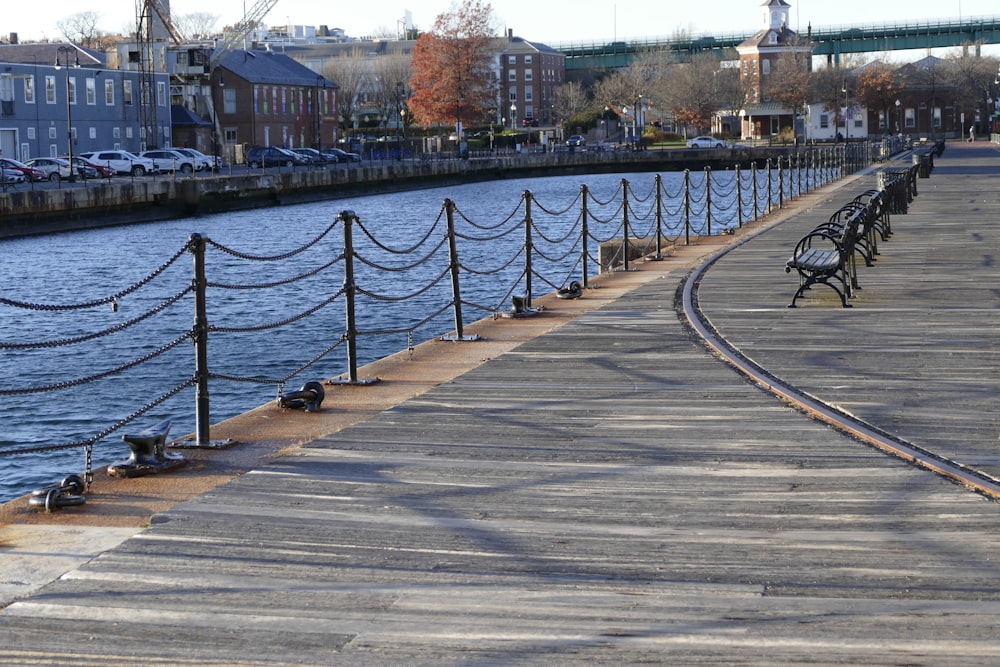 a row of benches sitting on the side of a river