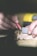 Close-up of hands measuring blueprints on a wooden table with construction tools nearby.