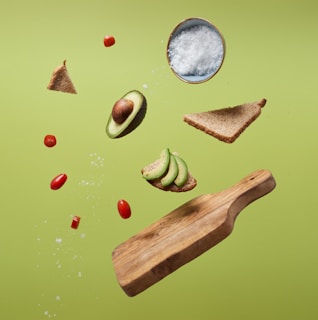 sliced avocado, tomatoes, and bread on a green surface
