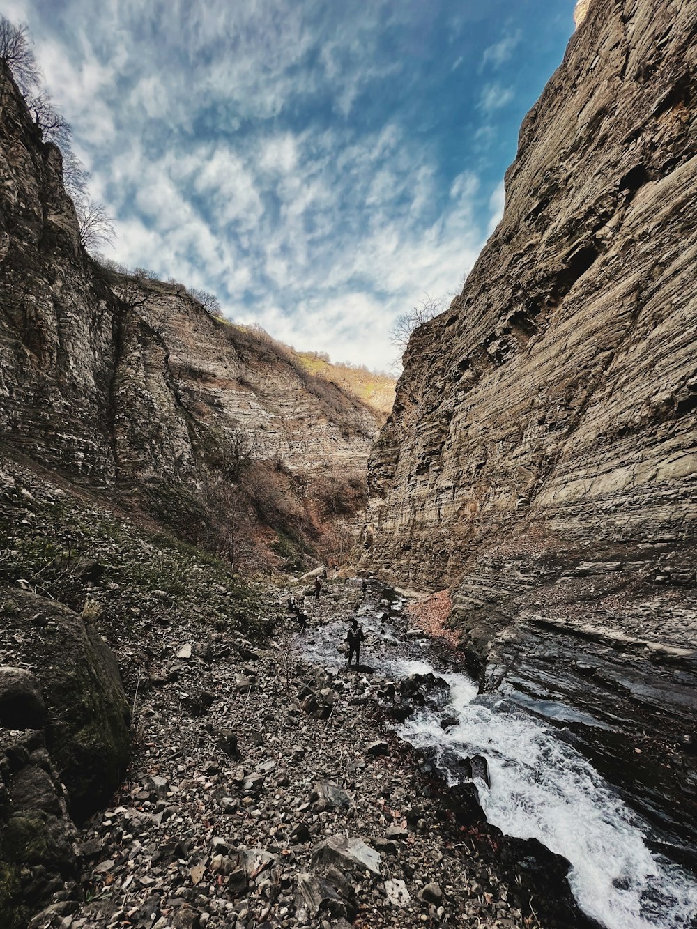 a man standing on the edge of a cliff next to a river