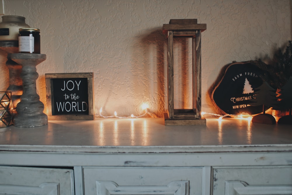 a white dresser topped with candles and a sign