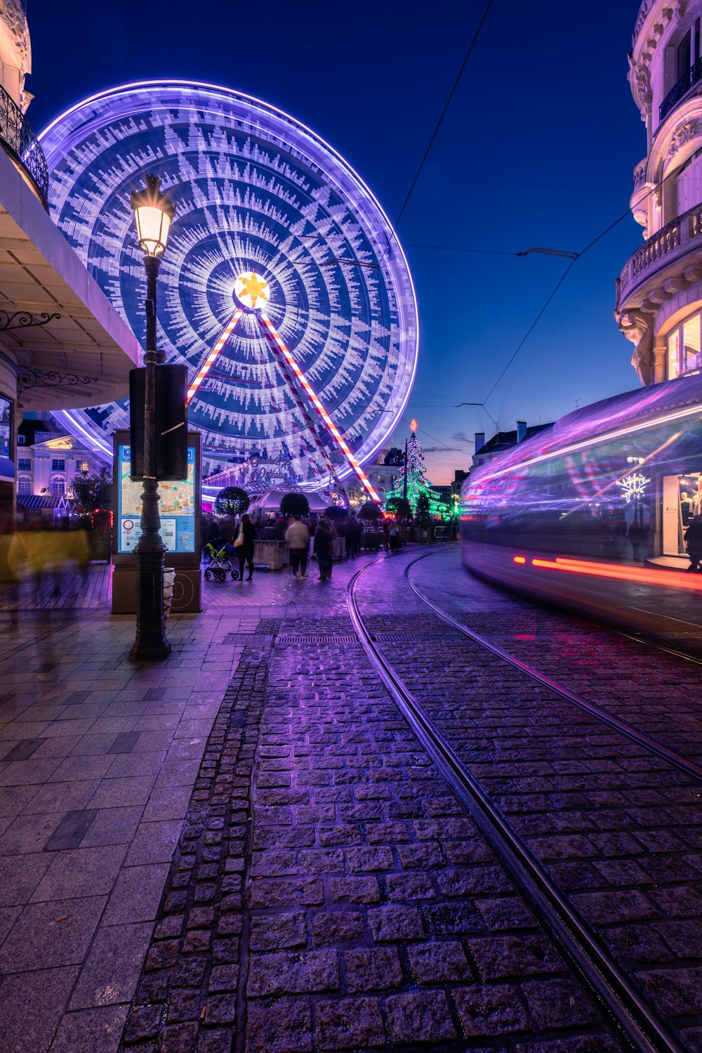 a ferris wheel lit up at night in a city