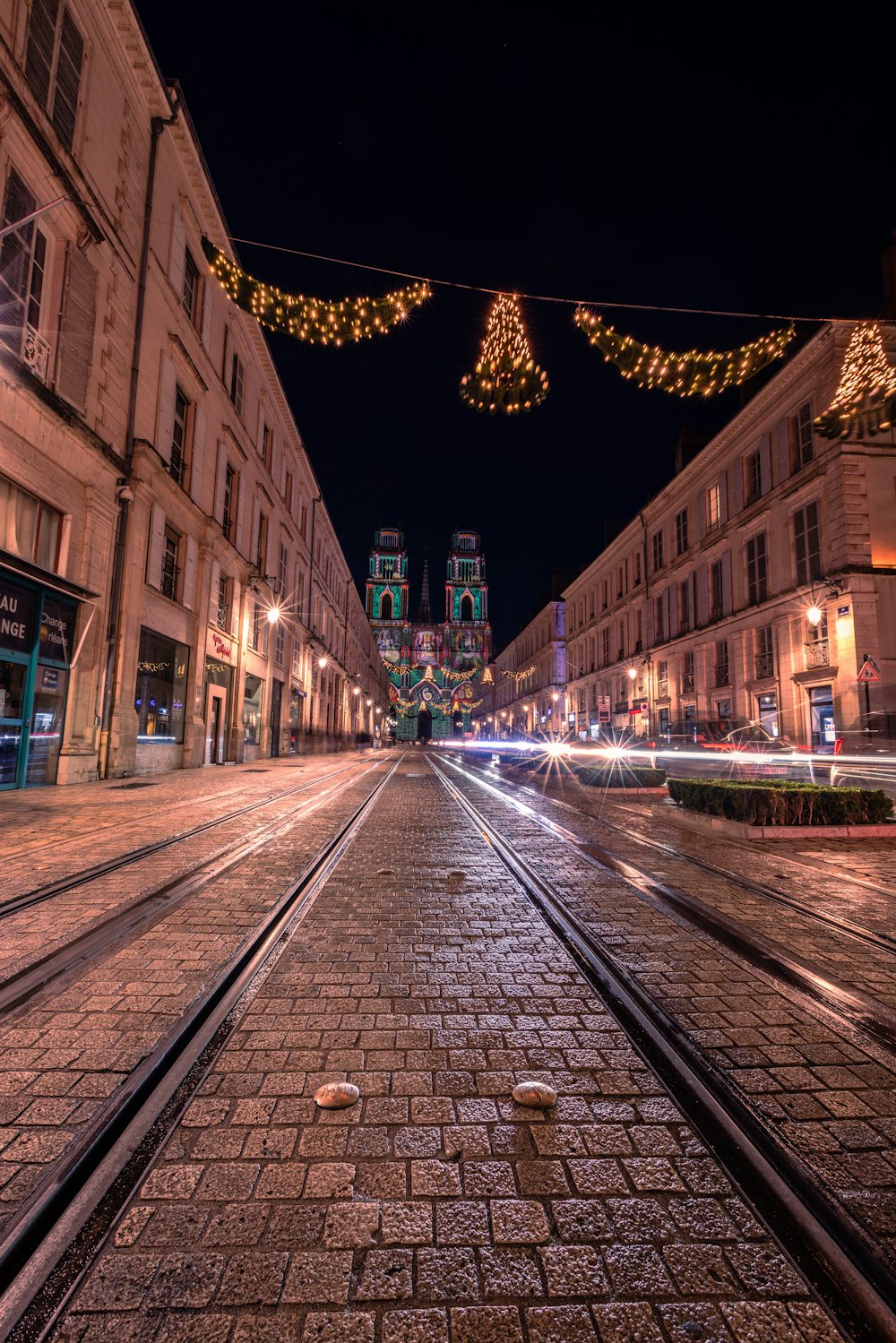 Una calle de la ciudad por la noche con luces navideñas