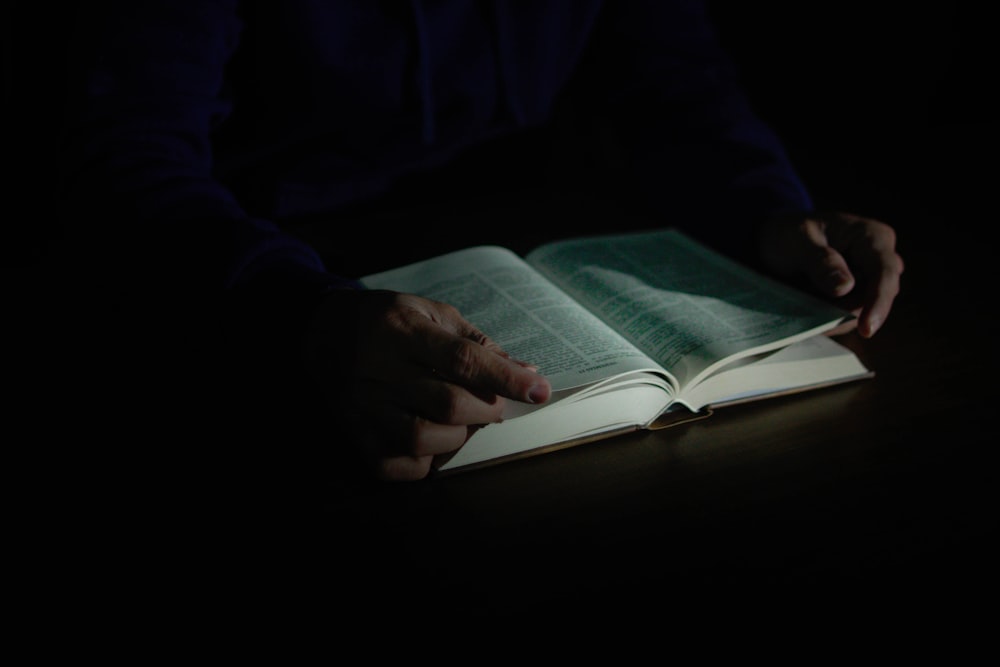 a person is reading a book in the dark