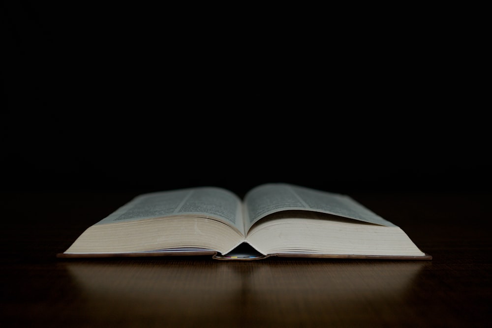 an open book sitting on top of a wooden table