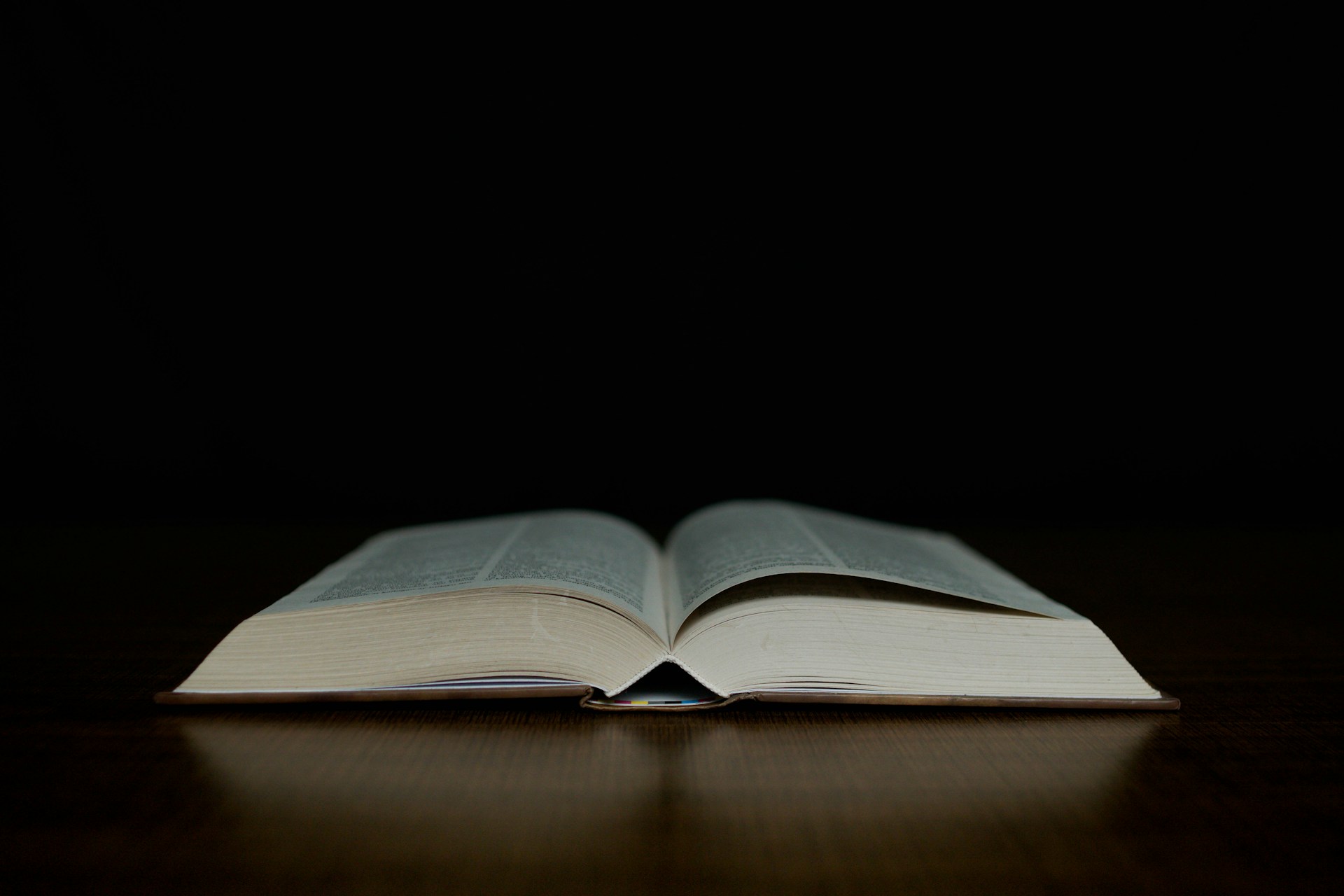 an open book sitting on top of a wooden table