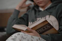a person sitting on a couch reading a book