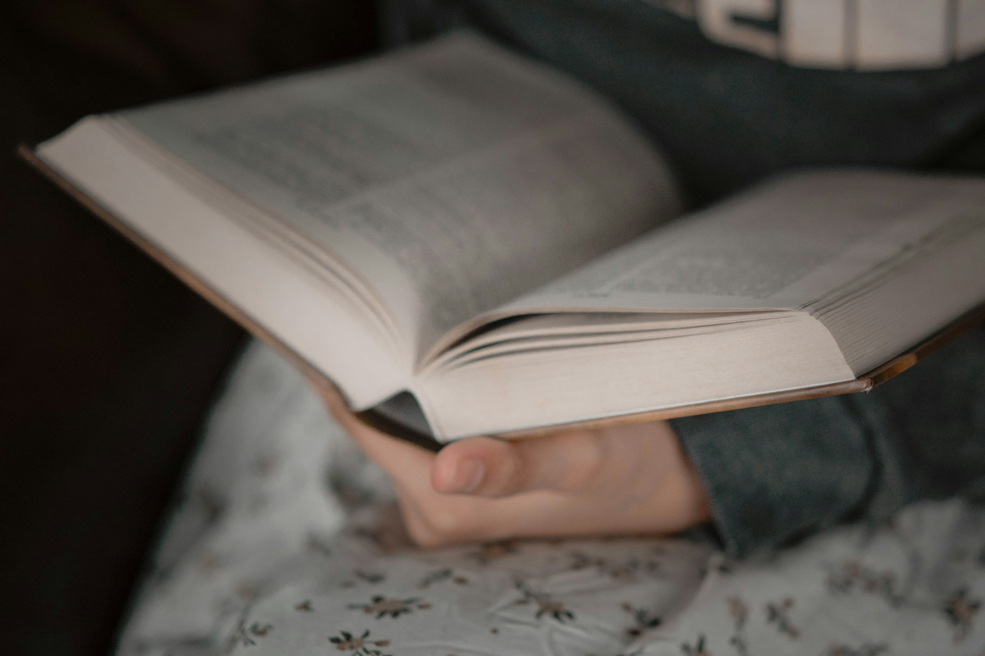 a person holding an open book in their hands