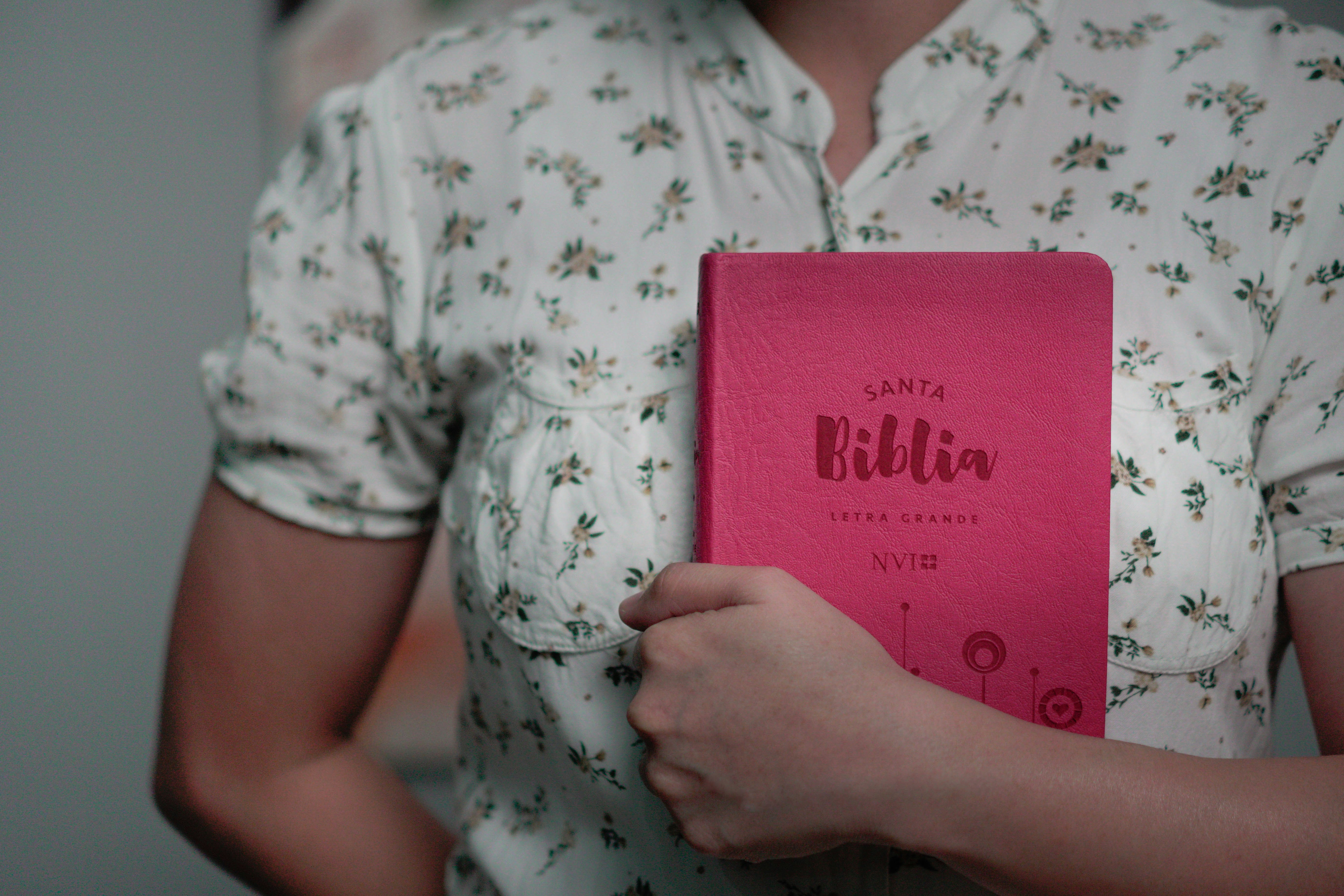 a woman holding a pink book in her hands