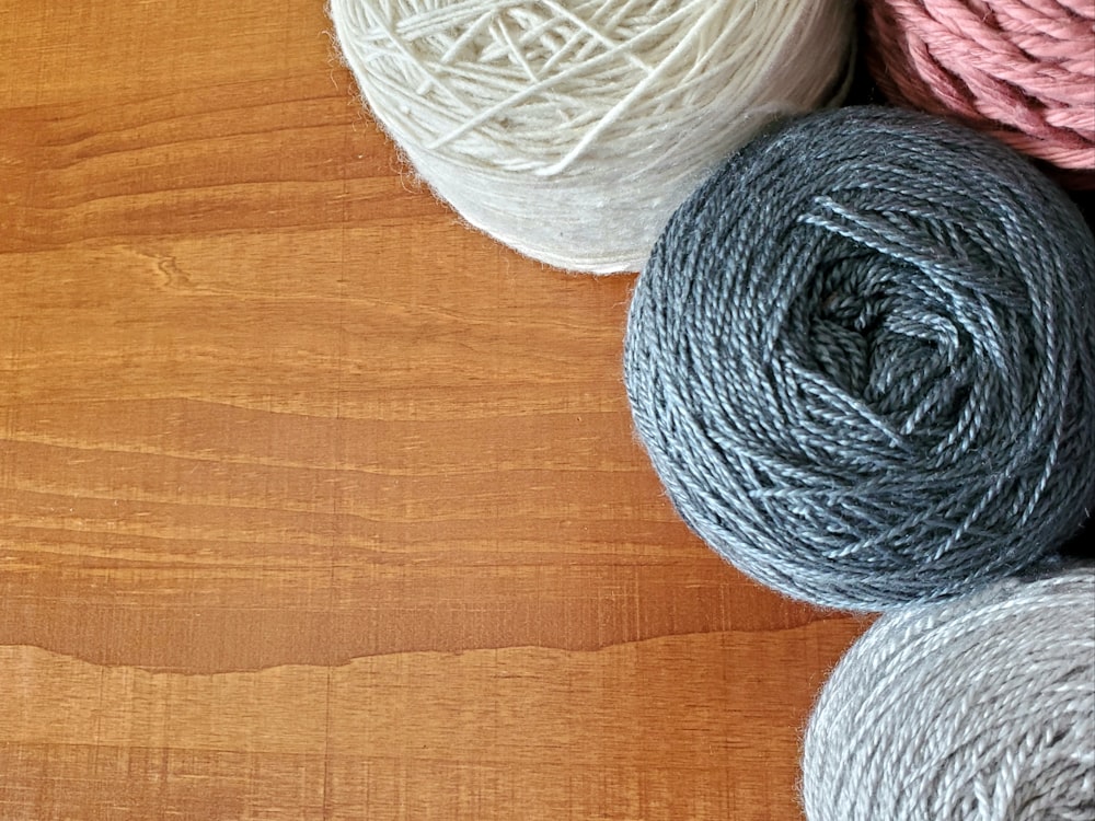 a group of balls of yarn sitting on top of a wooden table