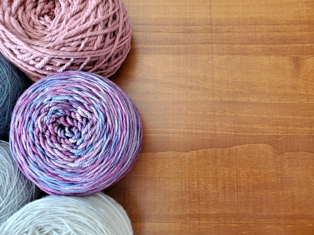 a group of balls of yarn sitting on top of a wooden table