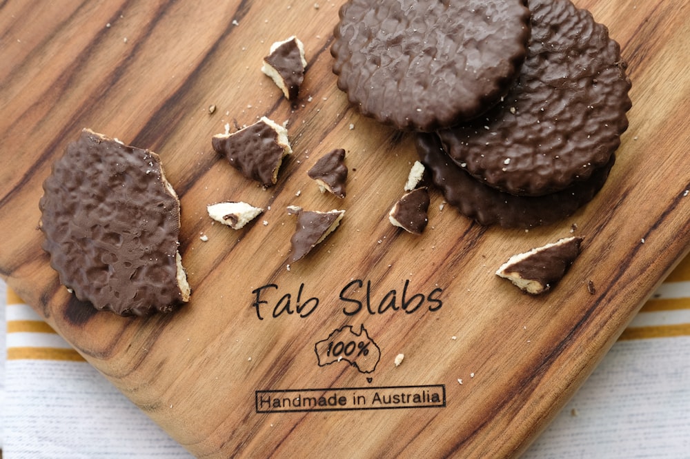 a wooden cutting board topped with chocolate covered cookies