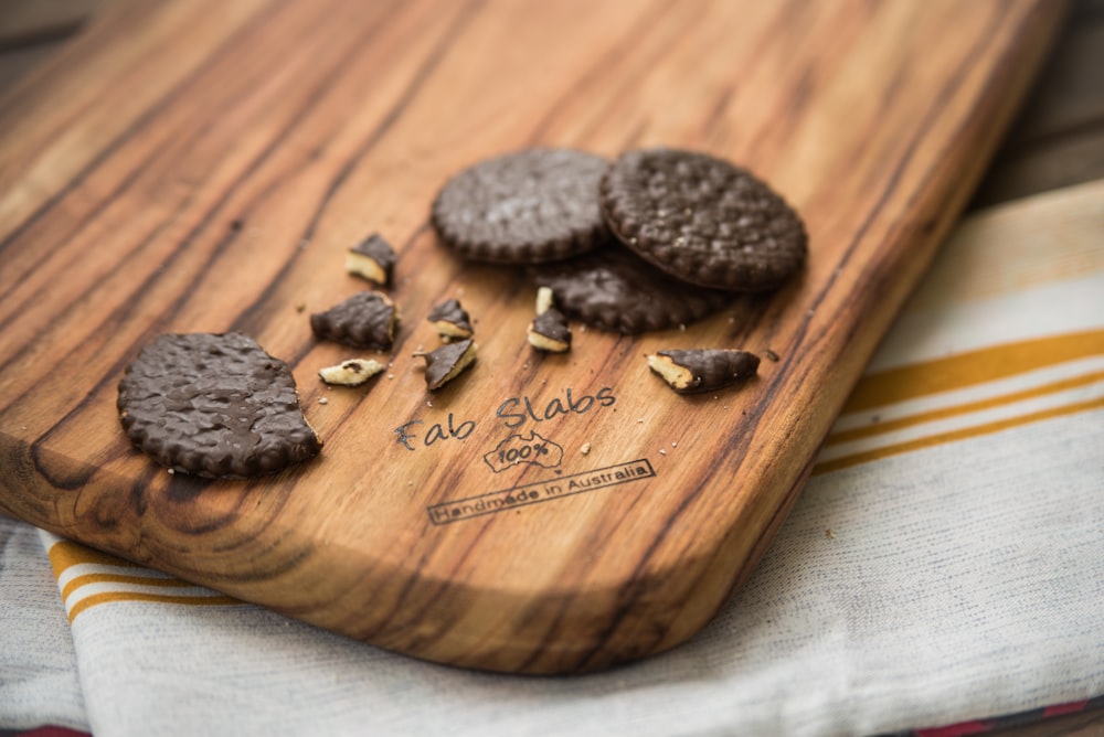 a wooden cutting board topped with cookies on top of a table