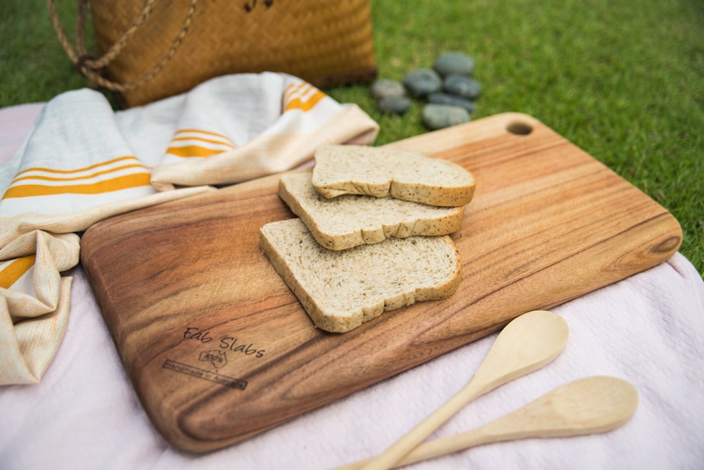 a wooden cutting board topped with slices of bread