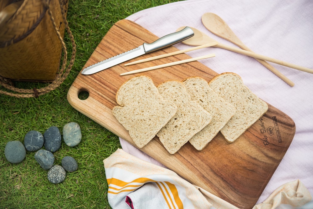 a wooden cutting board topped with slices of bread