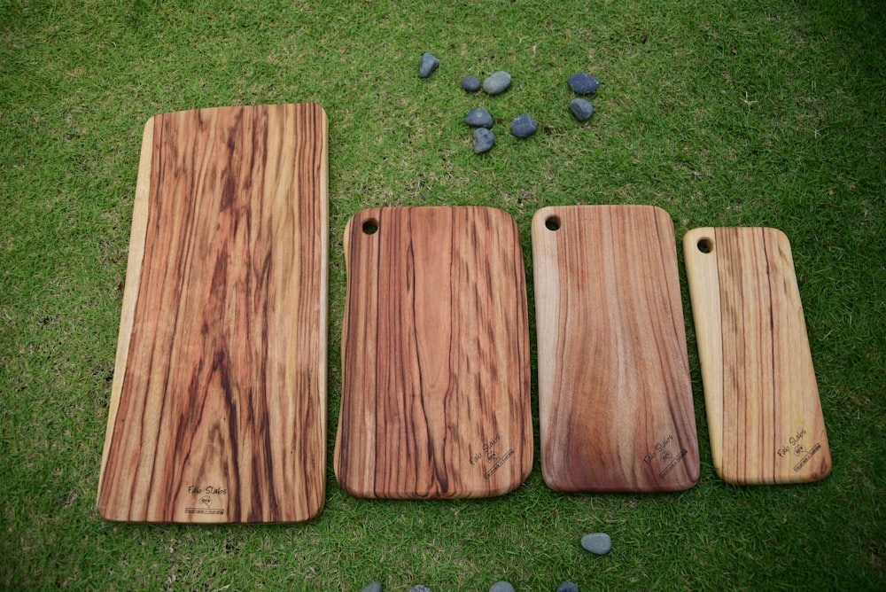 a group of three wooden boards sitting on top of a grass covered field