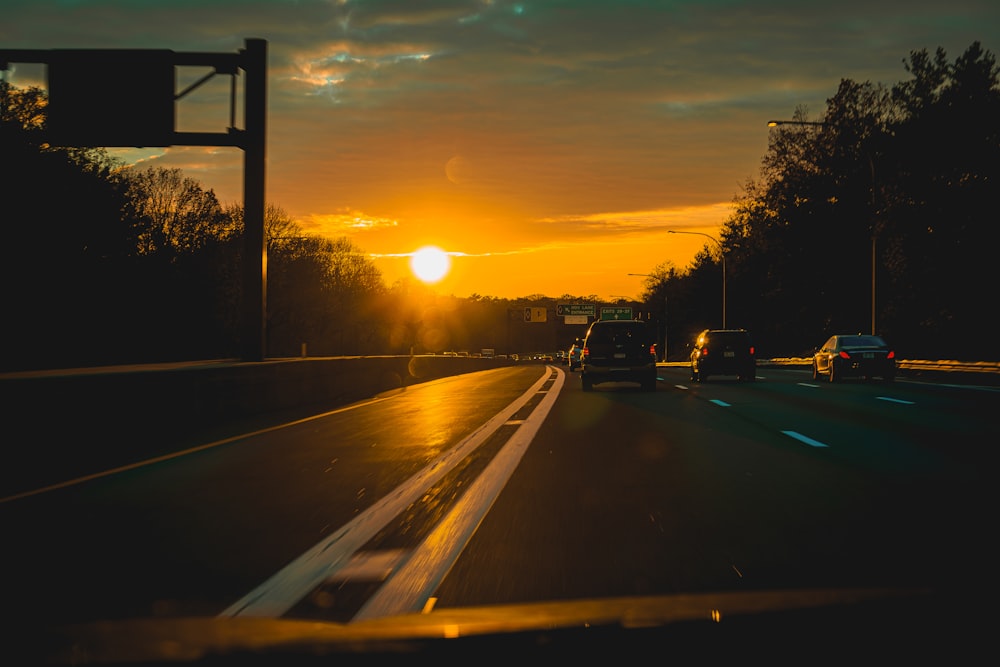 the sun is setting over a highway with traffic