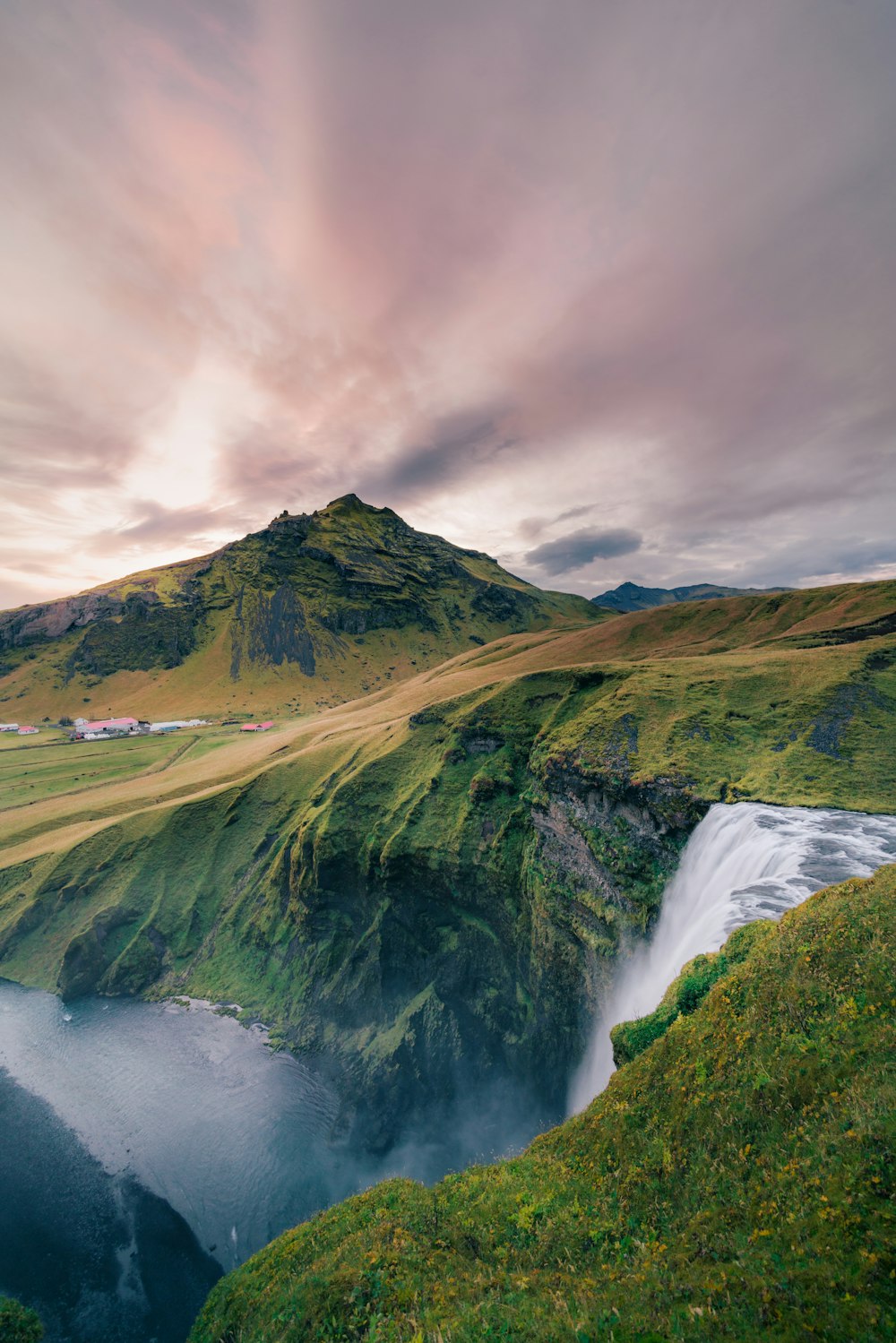 a large body of water surrounded by a lush green hillside