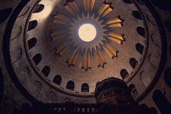 a large clock mounted to the side with Church of the Holy Sepulchre in the background