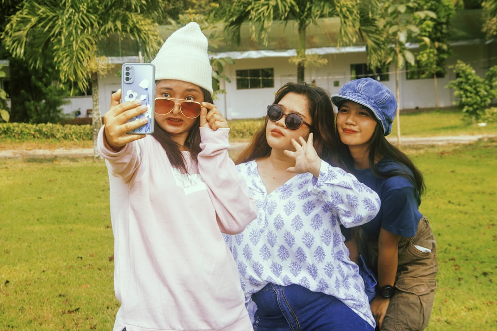 three girls taking a picture with their cell phones