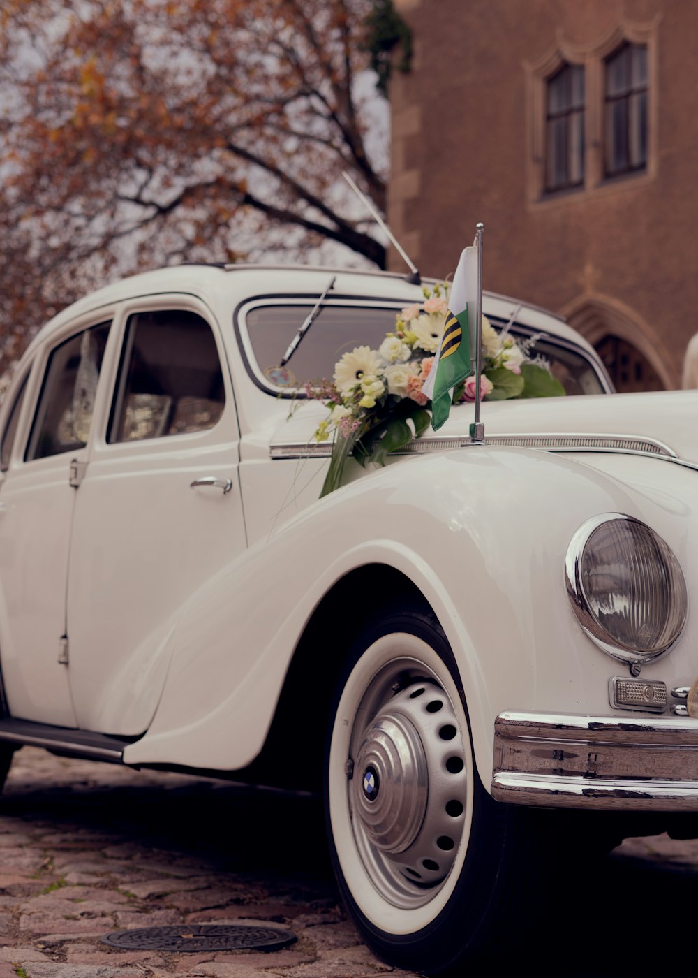 a white car with a flower arrangement on the hood