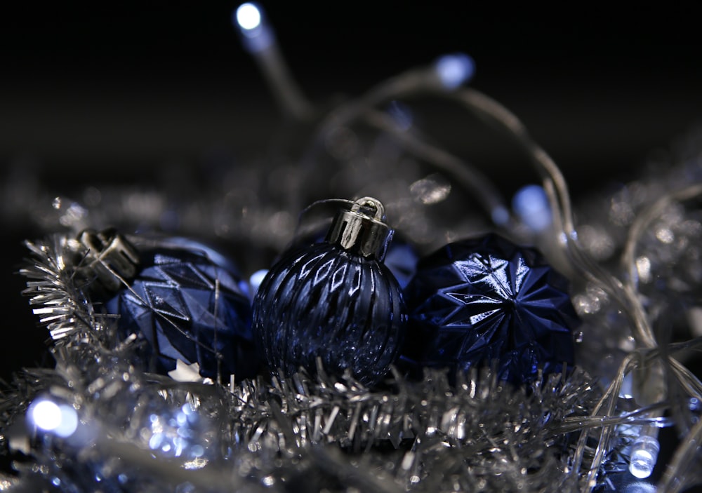 a bunch of blue ornaments sitting on top of a pile of tinsel