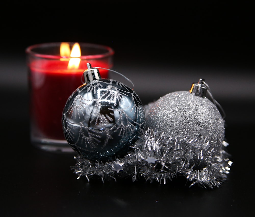 a couple of ornaments sitting next to a candle
