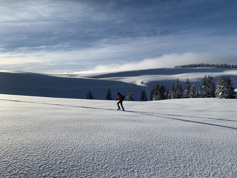 a person riding skis down a snow covered slope