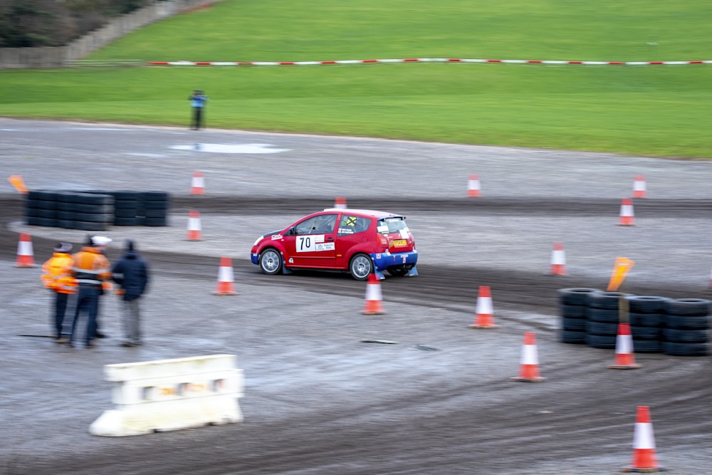 a small red car driving down a race track