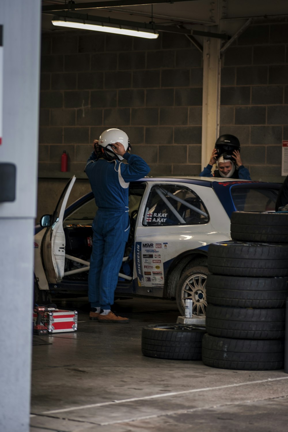 a man standing next to a car in a garage