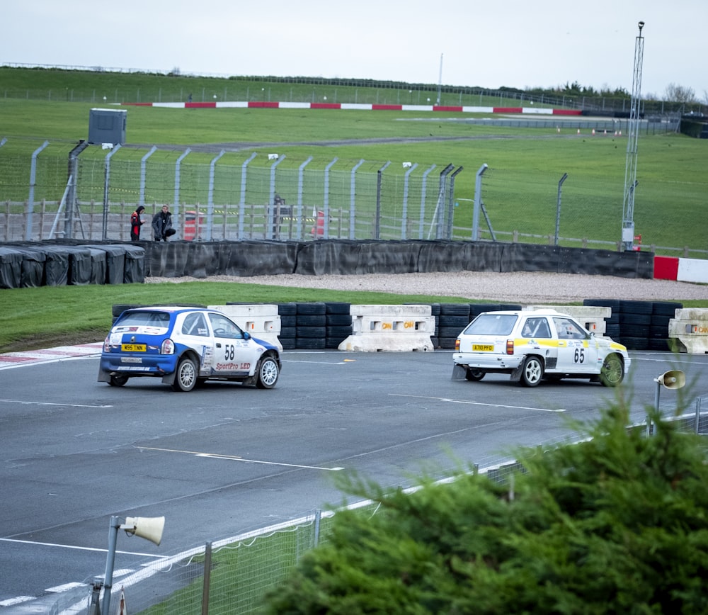 a couple of cars driving down a race track