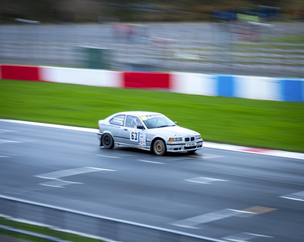 a white car driving down a race track