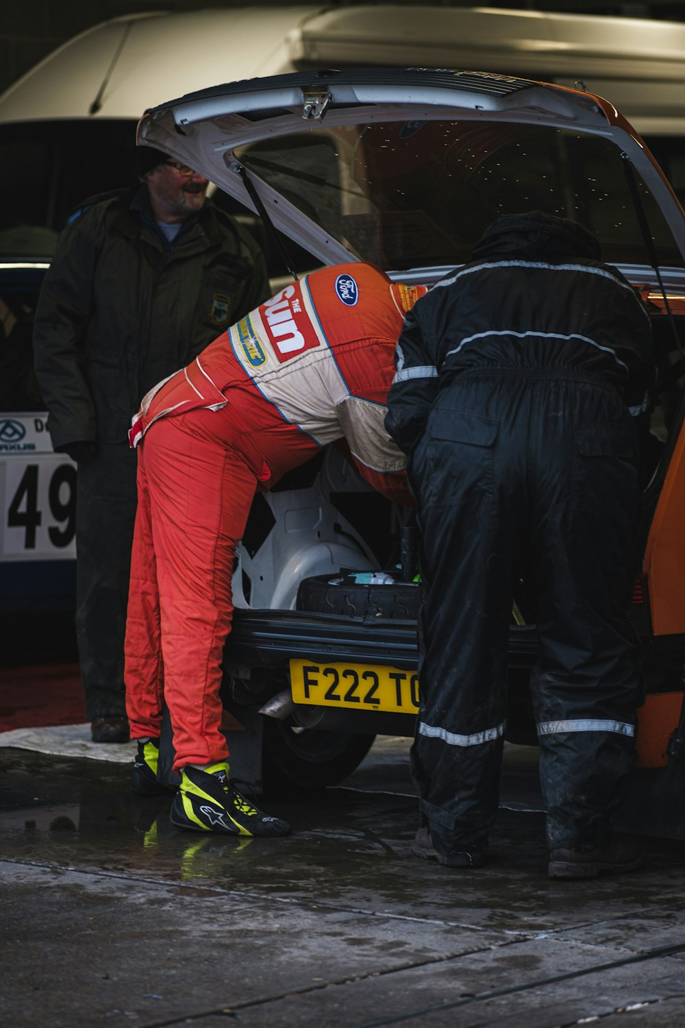 Due uomini che lavorano su un'auto in un garage