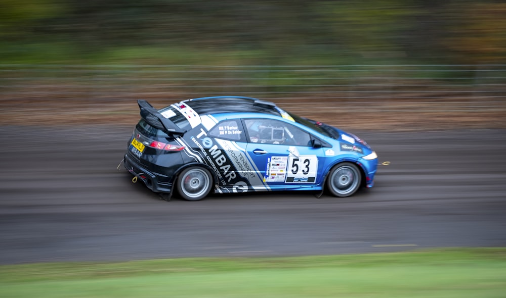 a small blue car driving down a race track