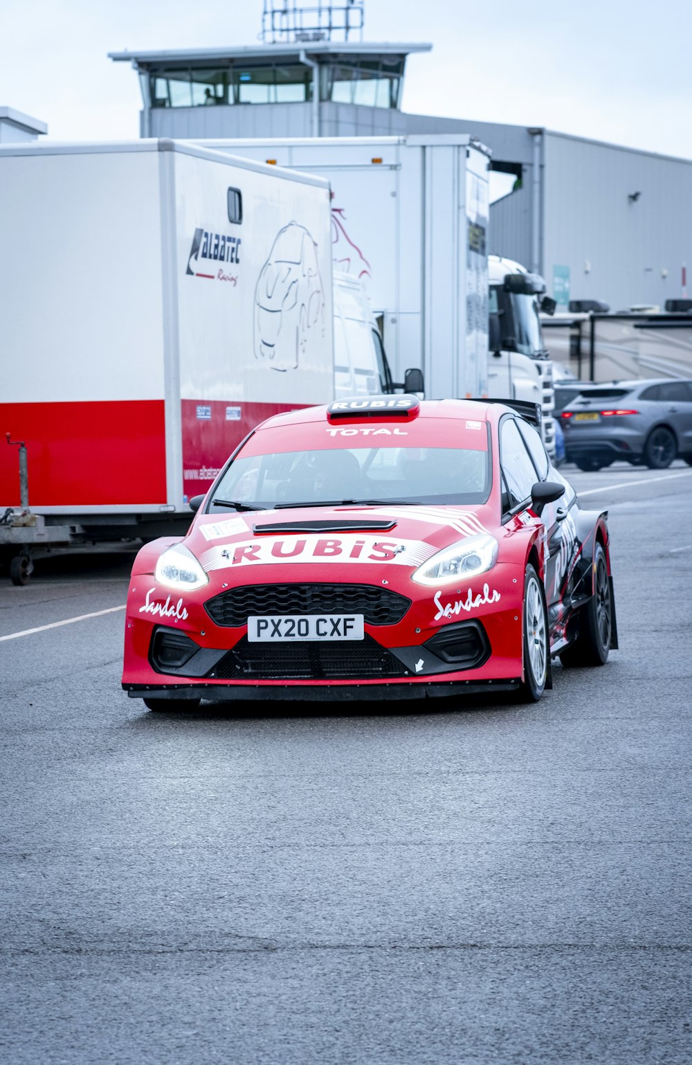 a red sports car driving down a race track