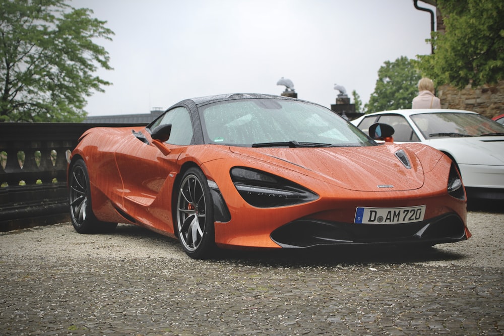 an orange sports car parked in a parking lot