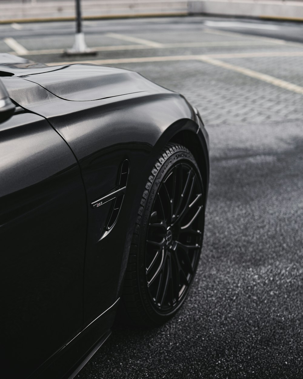 Un auto deportivo negro estacionado en un estacionamiento