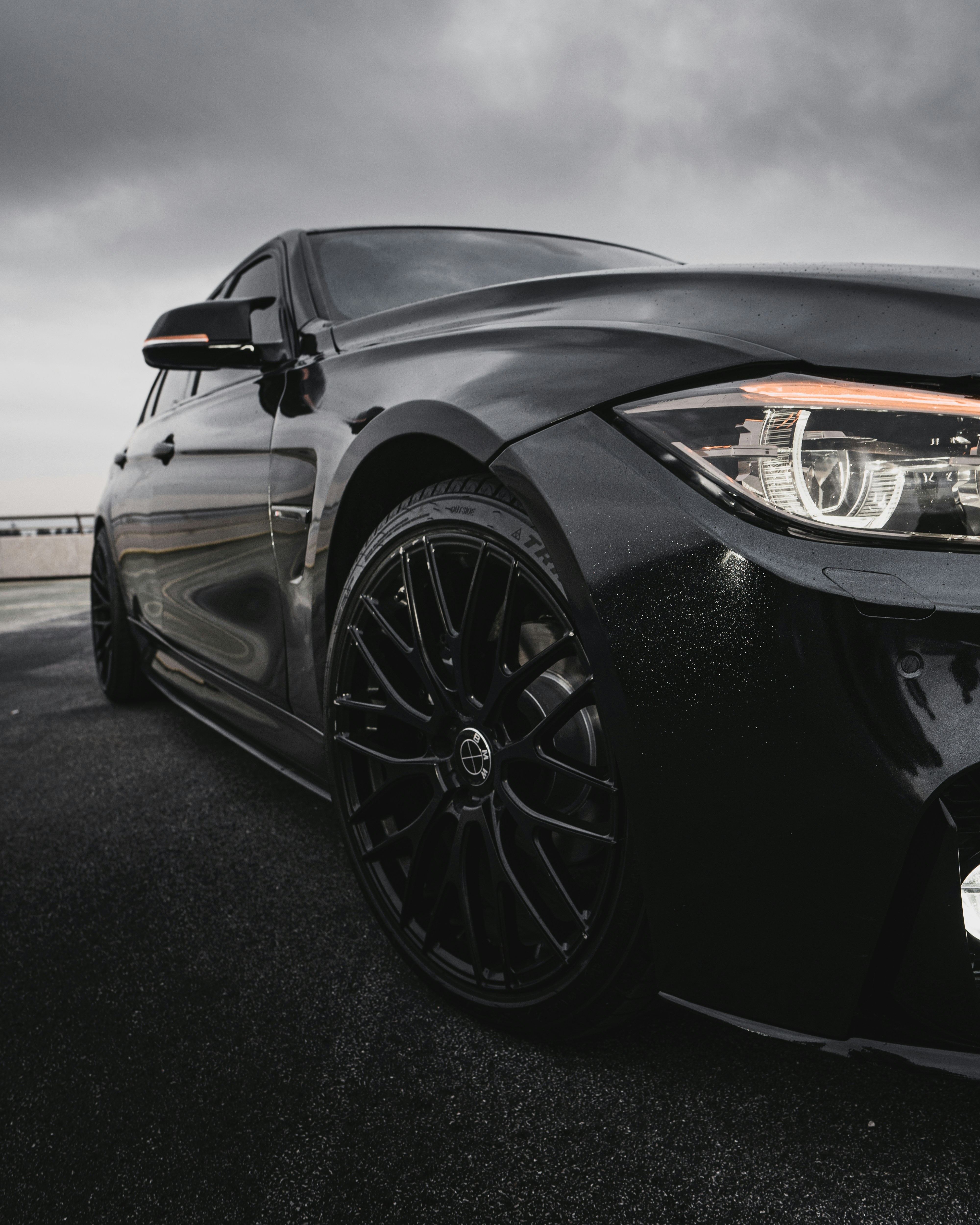 Ein schwarzes Auto, das auf einem Parkplatz unter einem bewölkten Himmel geparkt ist