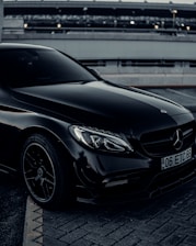 a black mercedes benz coupe parked in a parking lot