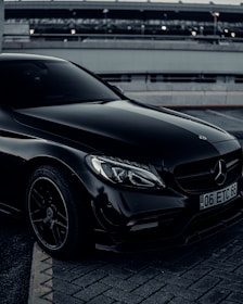 a black mercedes benz coupe parked in a parking lot