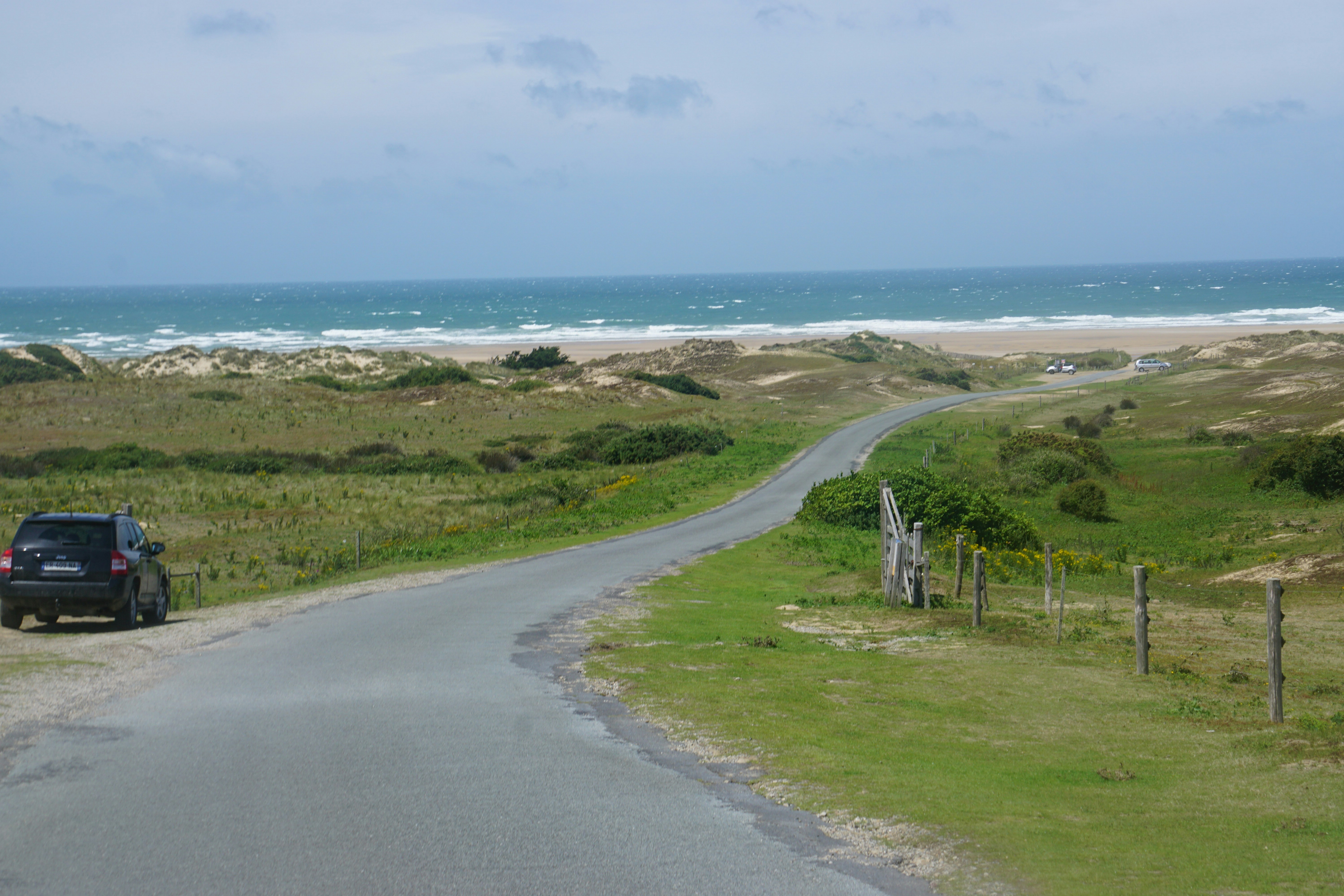 a car parked on the side of a road near the ocean