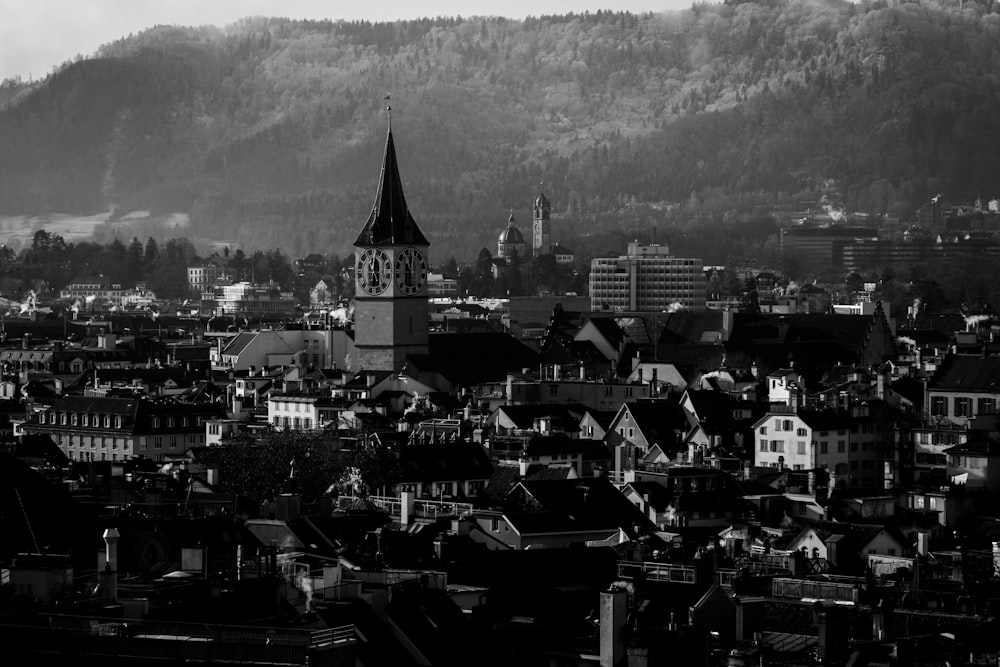 a black and white photo of a city with mountains in the background