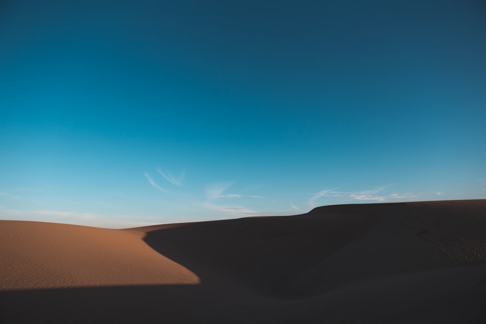 a person standing on top of a sand dune