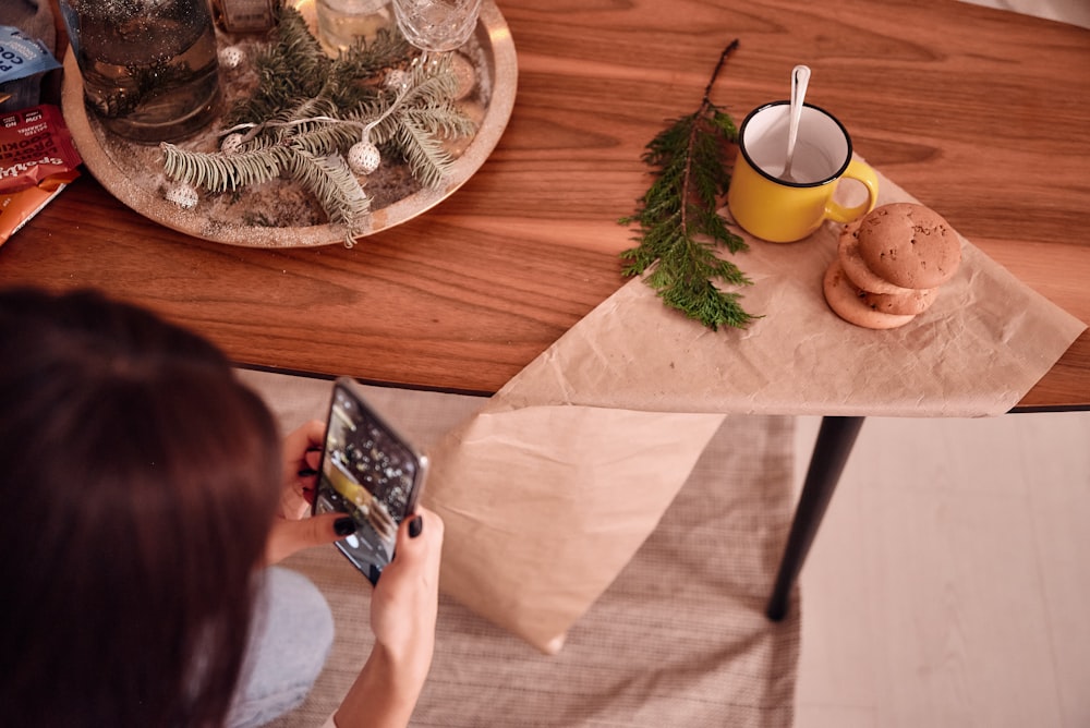 a woman is taking a picture of food on a table