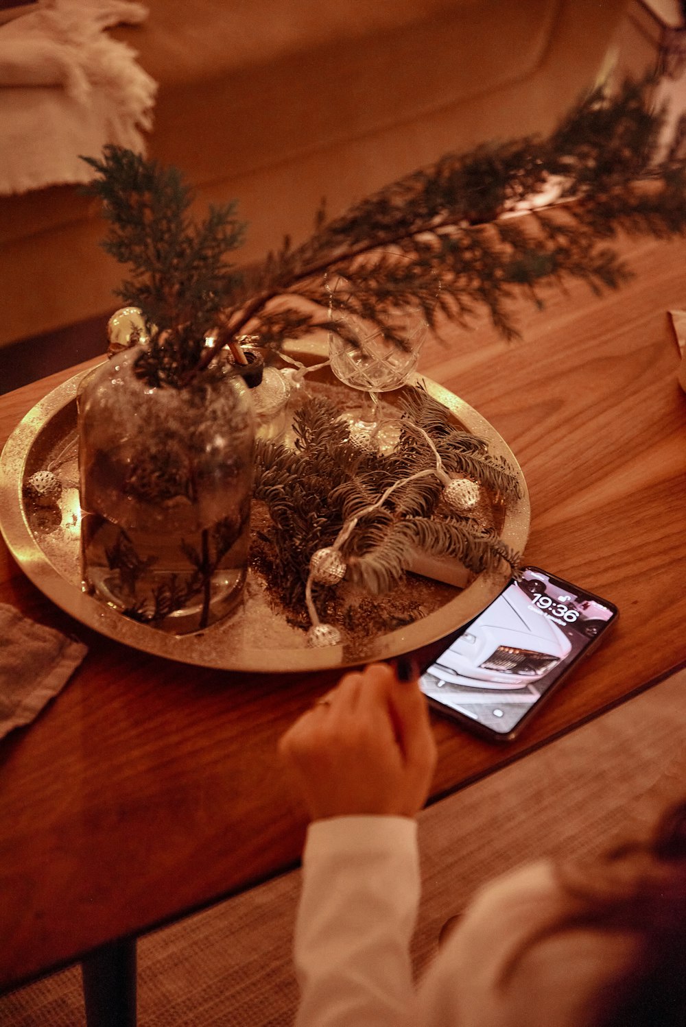 uma pessoa segurando um telefone celular na frente de uma árvore de Natal