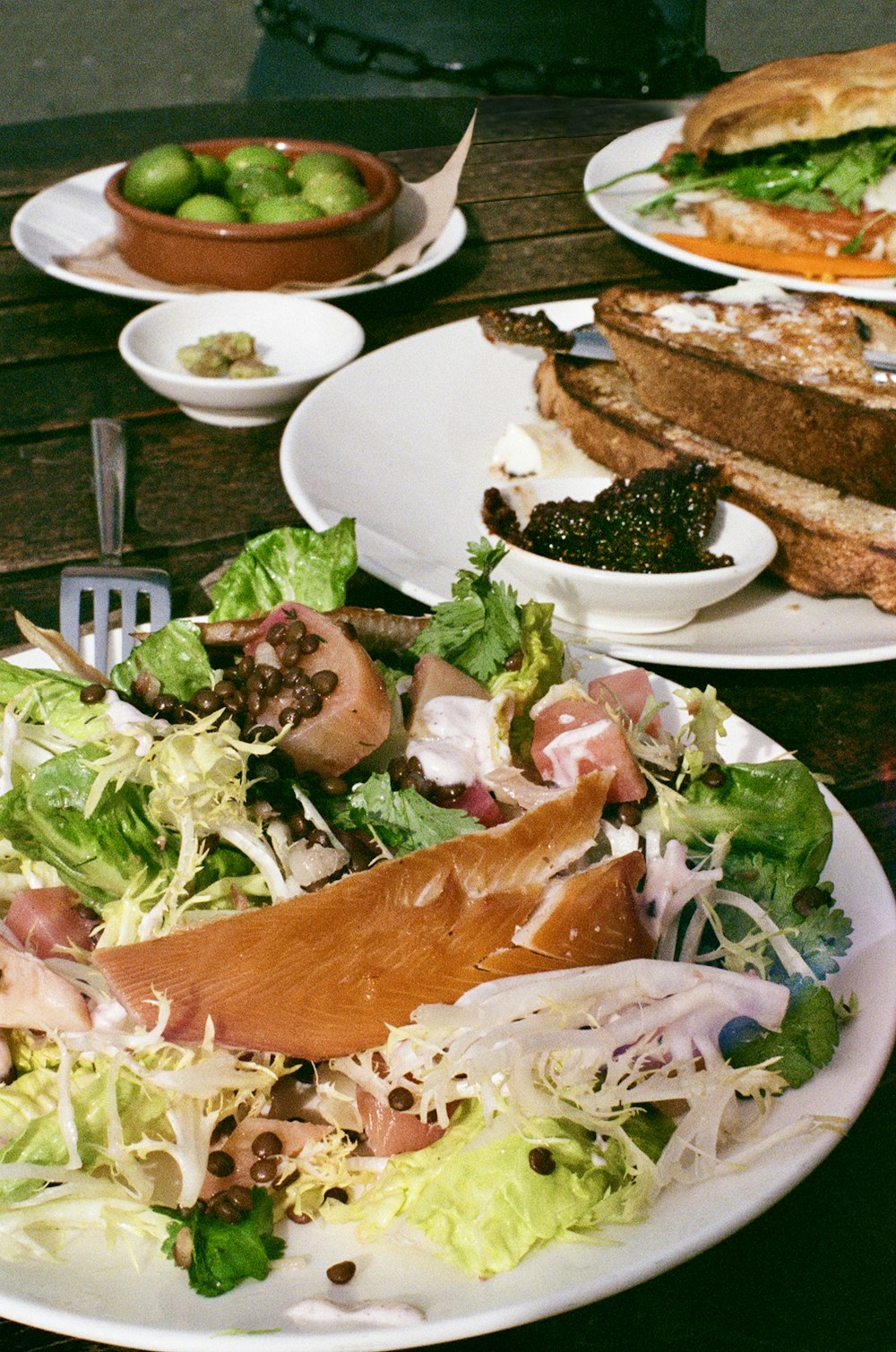 a plate of salad and a sandwich on a table