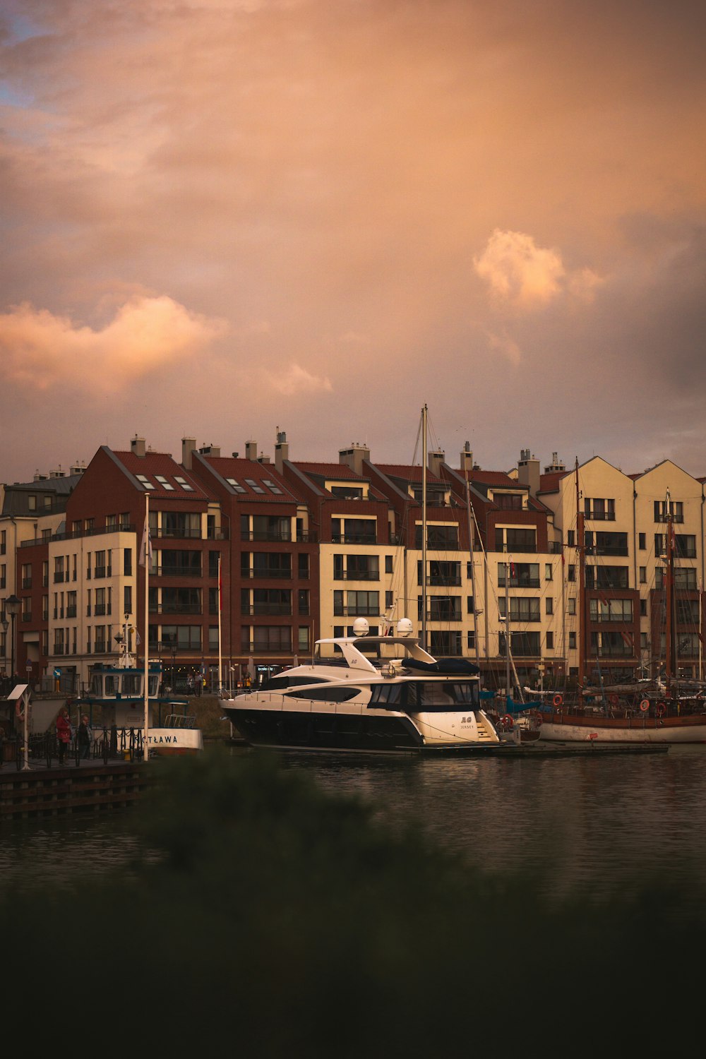 a boat is docked in front of a row of buildings